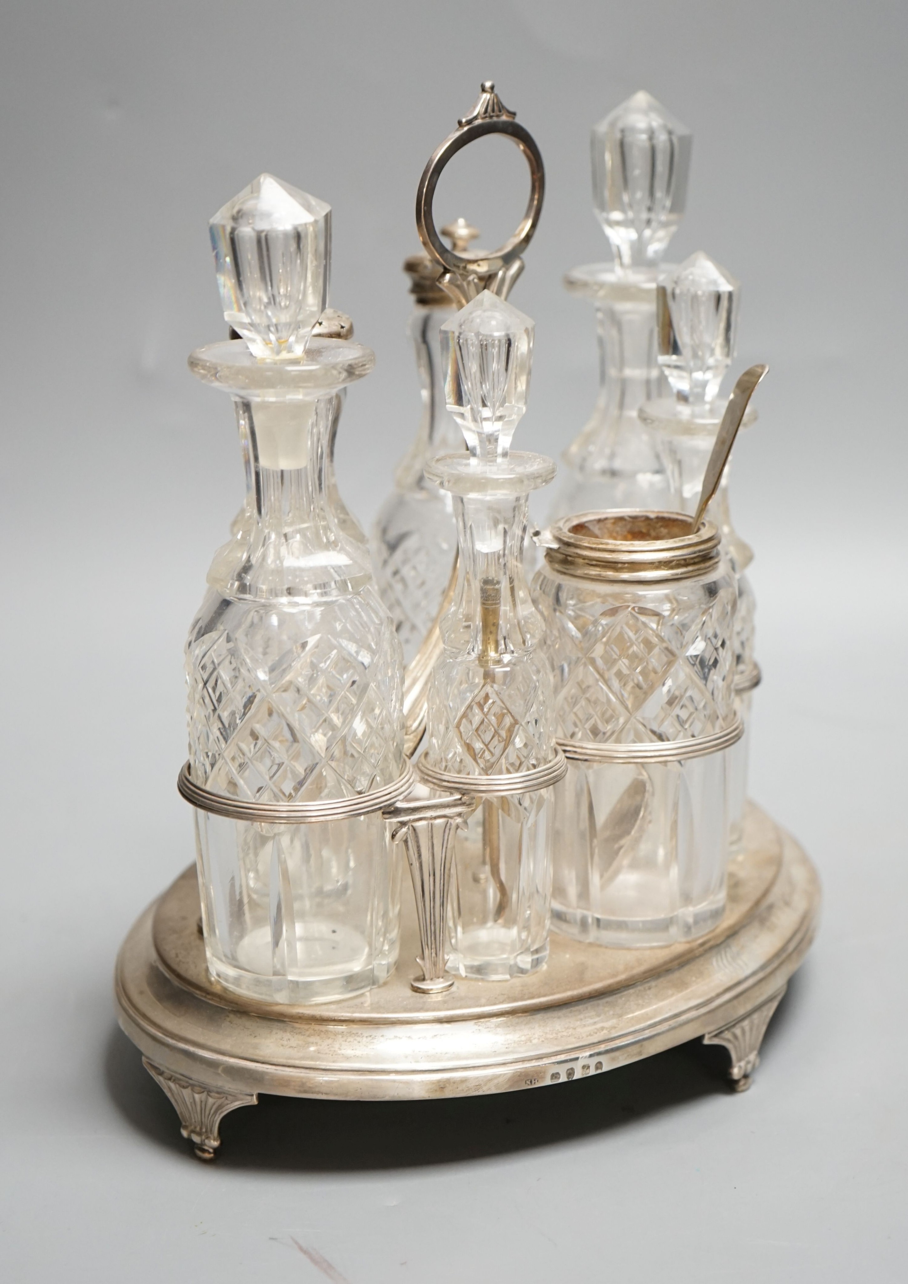 A George III silver oval cruet stand, Henry Nutting, London, 1805, height 25cm, 17.5oz, with six later associated glass bottles.